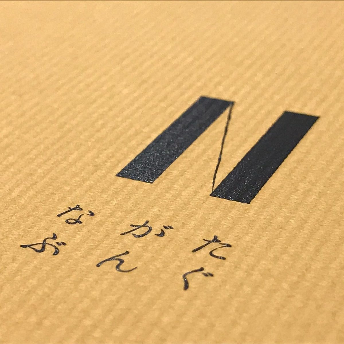 山吹色の紙に押されたロゴ
